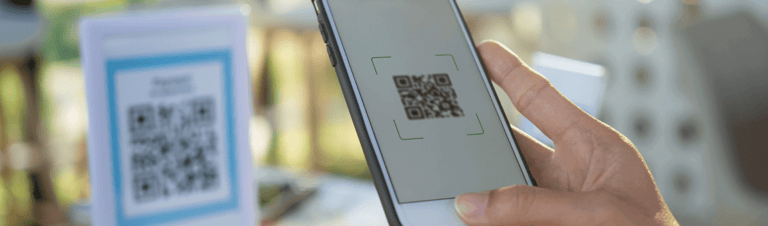 Pessoa com celular fazendo pagamento online com QR Code. 