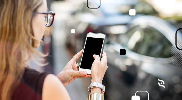 mulher de costas, usando celular com carro prata parado à sua frente