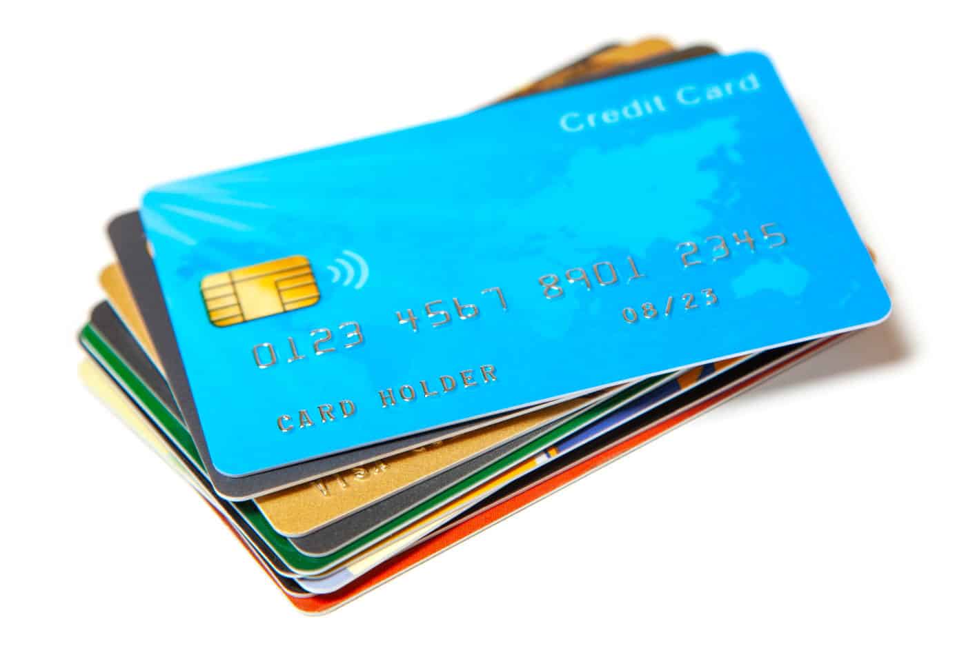 Imagem contendo vários cartões de crédito empilhados. O primeiro cartão da pilha é da cor azul