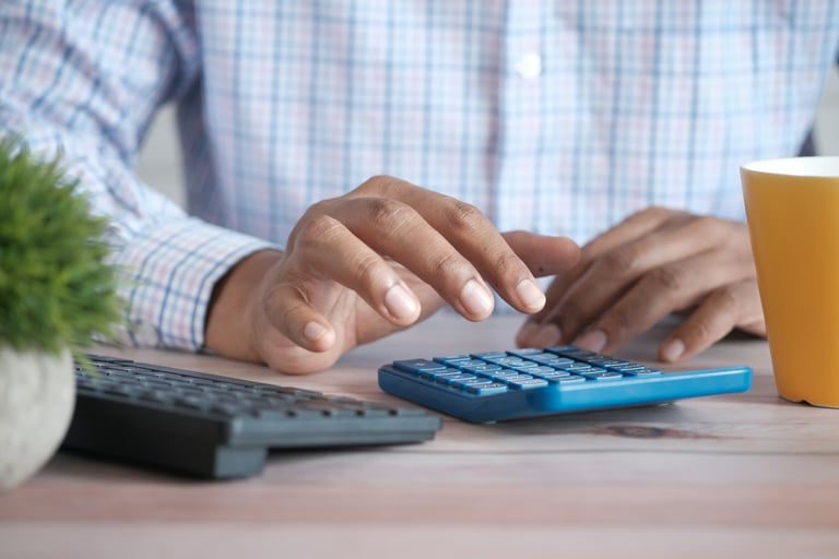 pessoa usa teclado de computador preto e calculadora azul para calcular honorários contábeis