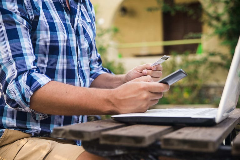 homem segurando um celular e um cartão de crédito fazendo um pagamento online