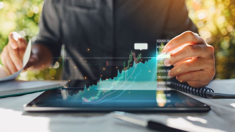 Imagem de um homem mostrando do pescoço para baixo, sentado de frente para uma mesa utilizando um tablet para fazer uma análise financeira. 