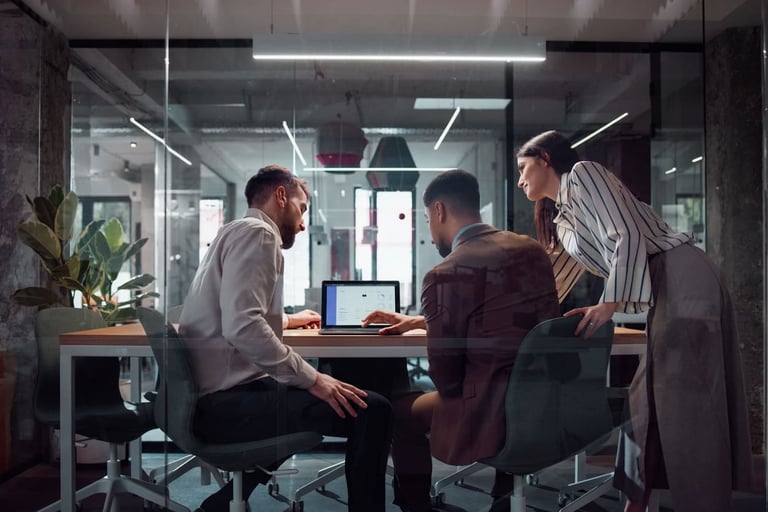Reunião de três colegas de trabalho discutindo ideias em uma sala de reunião moderna, com ambiente de escritório elegante e tecnologia de ponta.