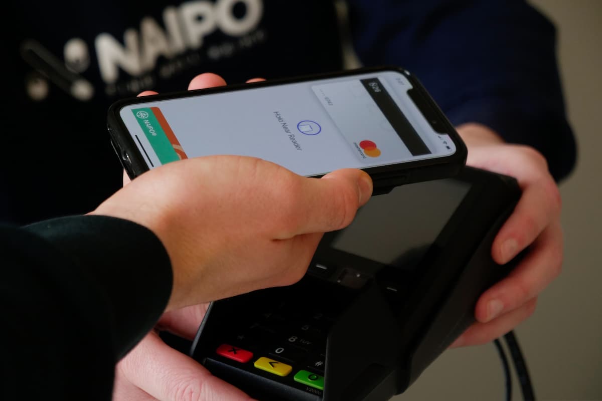 Máquina de cartão recebendo pagamento pelo celular. 