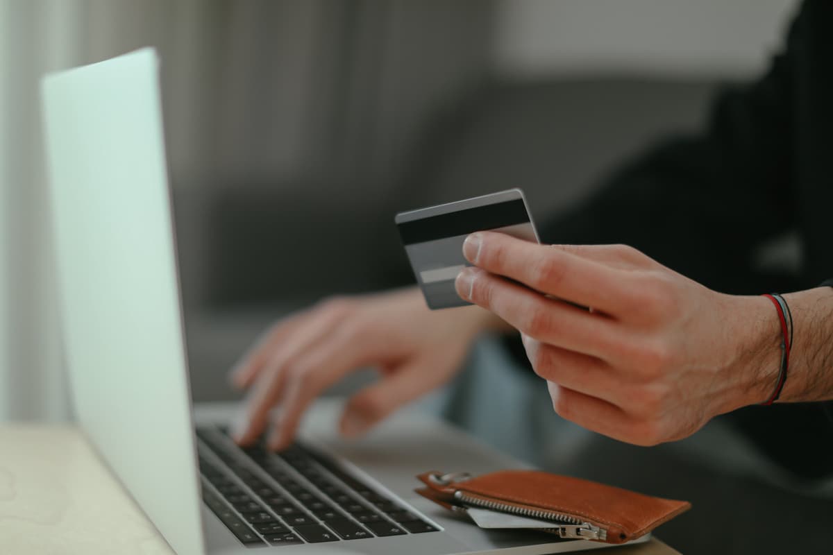 Realizando pagamento online com cartão de crédito e notebook. 